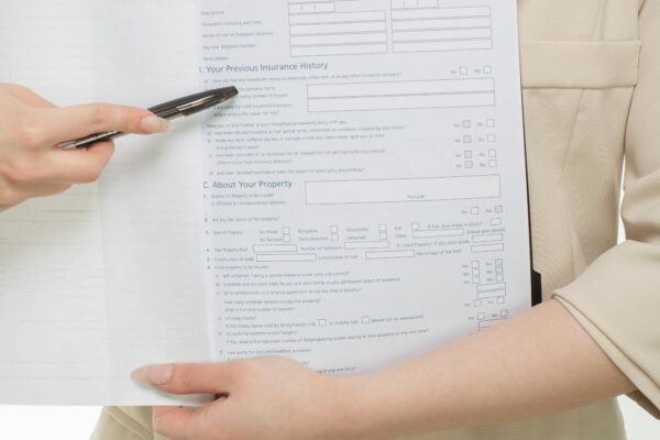 Close-up of a professional presenting insurance paperwork with a pen.